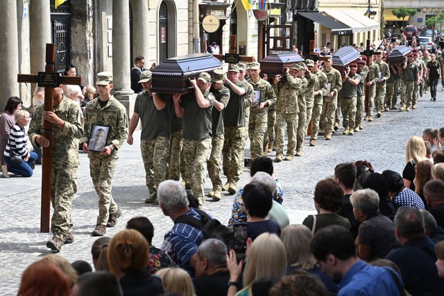 Soldados ucranianos cargan los ataúdes de doce militares y prisioneros de guerra ucranianos, que murieron en cautiverio ruso, durante una ceremonia fúnebre en Lviv, oeste de Ucrania, el 25 de julio de 2025, durante la invasión rusa de Ucrania. Foto: YURIY DYACHYSHYN / AFP