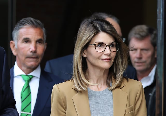 Actor Lori Loughlin and Mossimo Giannulli, wearing green tie at left, leave the John Joseph Moakley United States Courthouse in Boston on April 3, 2019.