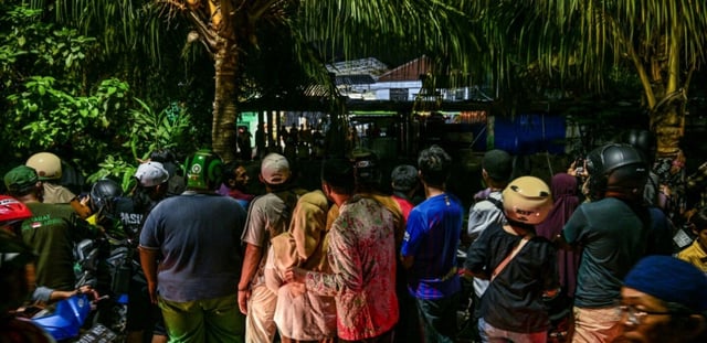 Des personnes regardent une opération de secours sur le site d'une école islamique mixte Al Khoziny qui s'est effondrée à 30 km de Surabaya, dans l'est de la grande île de Java, le 25 octobre 2025