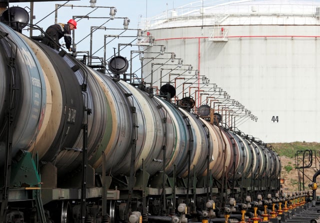 A worker controls the freight level of a tanker wagon at the Rosneft oil terminal in Arkhangelsk, May 30, 2007. REUTERS/Sergei Karpukhin/File Photo