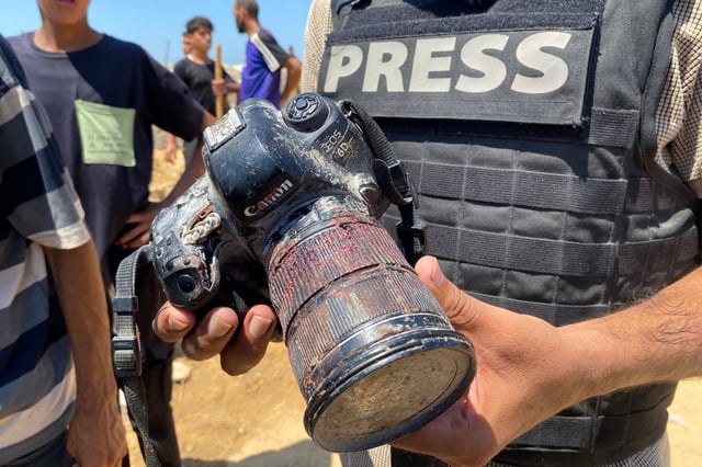 Un periodista sostiene una cámara ensangrentada perteneciente al fotoperiodista palestino Hussam al-Masri, contratista de Reuters, quien murió en un ataque israelí contra el hospital Nasser en Khan Yunis, al sur de Gaza. (Foto de AFP).