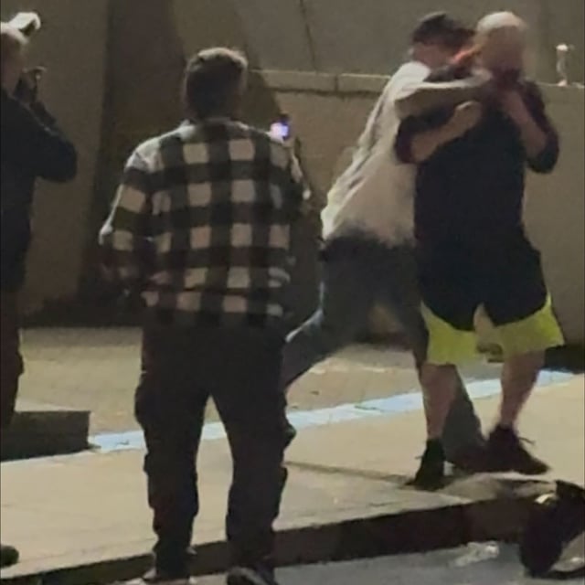 The Trump supporter in a white shirt and an ICE protester in the black hoodie exchange blows. Photo by Victor Park/KATU