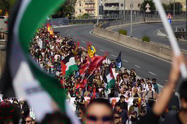 Pro-Palestinian demonstrators march along the Rome's ring road as they gather for a national general strike called by different unions to protest against the situation in Gaza two days after Israeli forces intercepted a Gaza-bound aid flotilla in the Mediterranean Sea, in Rome, Friday, Oct. 3, 2025. (AP Photo/Alessandra Tarantino)