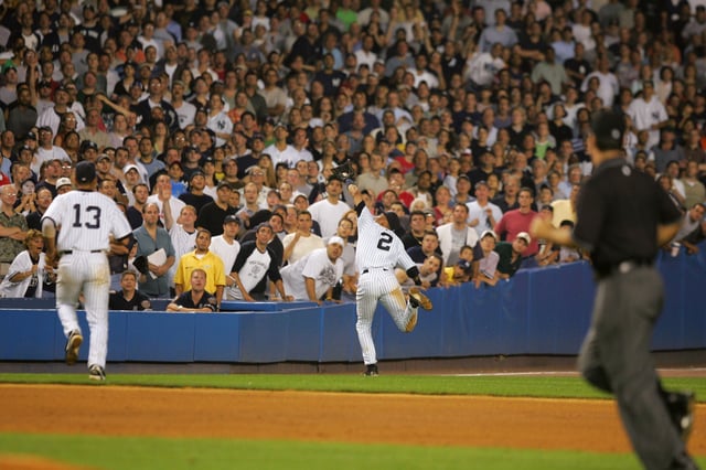NEW YORK - JULY 1: Derek Jeter #2 of the New York Yankees catches a foul ball before he dives into the stands in the 12th inning of the game against the Boston Red Sox on July 1, 2004 at Yankee Stadium in the Bronx, New York. The Yankees won 5-4 in 13 innings.  (Photo by Ezra Shaw/Getty Images)