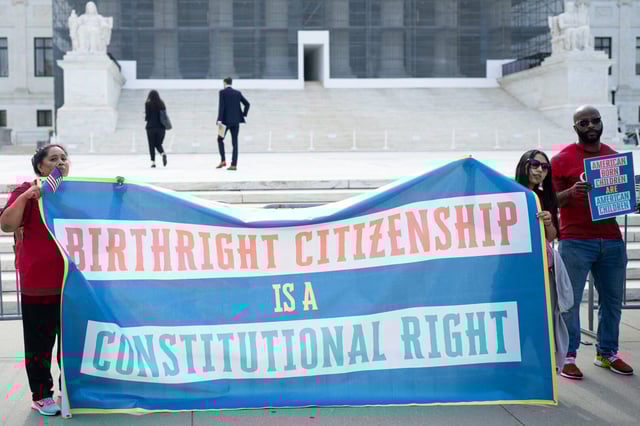 Activists gather with signs at the Supreme Court before oral arguments in May on a case last term about how to bring legal challenges to President Donald Trump‘s birthright citizenship executive order.