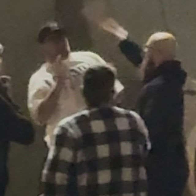A Trump supporter in a white shirt and an ICE protester in a black hoodie exchange blows. Photo by Victor Park/KATU