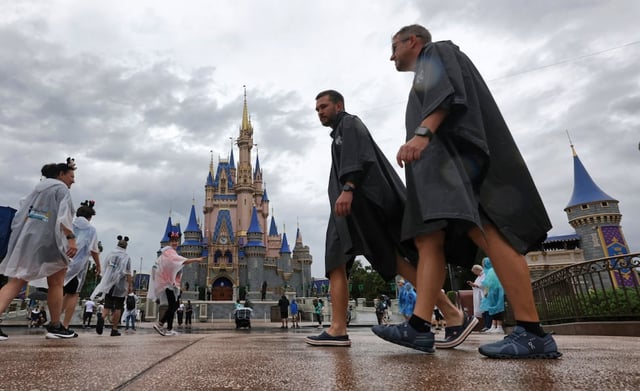 Guests weather early bands of rain from Hurricane Milton at the Magic Kingdom at Walt Disney World in Bay Lake, Fla., Wednesday, Oct. 9, 2024.