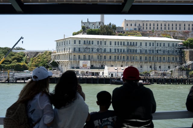 People watch as the ferry approaches Alcatraz in San Francisco Bay, June 18, 2025.