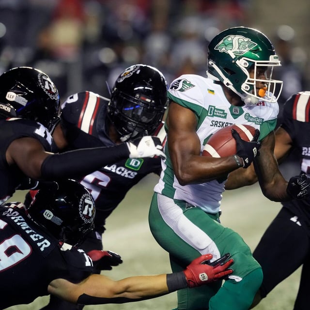 Ottawa Redblacks players bring down Saskatchewan Roughriders wide receiver Shawn Bane Jr. (15) as he returns a punt during first half CFL action in Ottawa on Friday, Oct. 3, 2025. THE CANADIAN PRESS/Adrian Wyld
