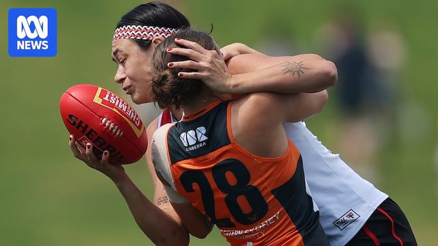 Jesse Wardlaw of the Saints is tackled by Daisy Walker of the Giants during an AFLW match.