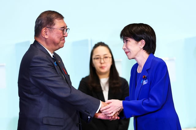 Newly-elected leader of Japan's Liberal Democratic Party (LDP) Sanae Takaichi shakes hands with Prime Minister Shigeru Ishiba after winning the LDP leadership election in Tokyo, Japan, October 4, 2025. REUTERS/Kim Kyung-Hoon/Pool