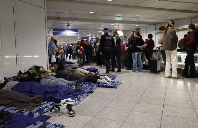 Passengers slept on inflatable mattresses on the ground while others queued up next to them at Munich International Airport in Munich, southern Germany, on October 4, 2025, after reports of drone sightings forced the airport to close for a second time in two days.