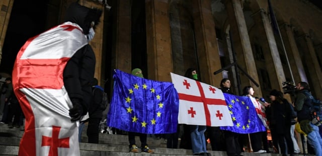 Des manifestants brandissent les drapeaux de la Géorgie et de l'Union européenne lors de la vague de contestation qui a suivi les élections législatives de 2024, le 5 décembre 2024 à Tbilissi