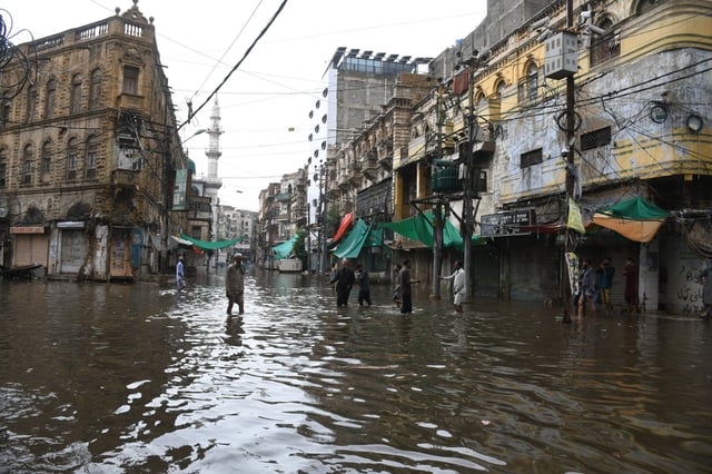 KARACHI, PAKISTAN, JULY 25: People hardly walk through flooded street after heavy monsoon rains hits Karachi, Pakistan, on July 25 2022. Several people lost their lives in floods due to heavy monsoon in Pakistan since monsoon season have started in June 2022. (Photo by Sabir Mazhar/Anadolu Agency via Getty Images)