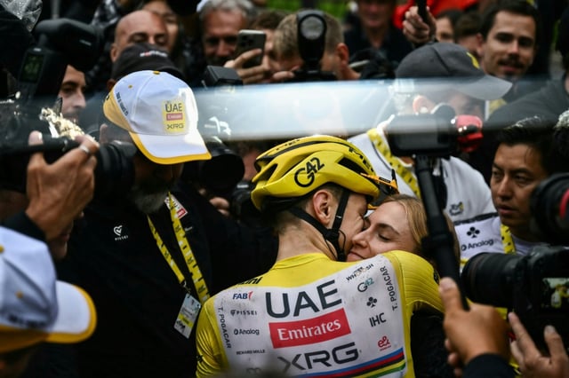 Le cycliste slovène Tadej Pogacar affiche son bonheur avec sa copine, également cycliste, Urska Zigart, à l'arrivée de l'ultime étape du Tour de France aux Champs-Elysées à Paris, le 27 juillet 2025