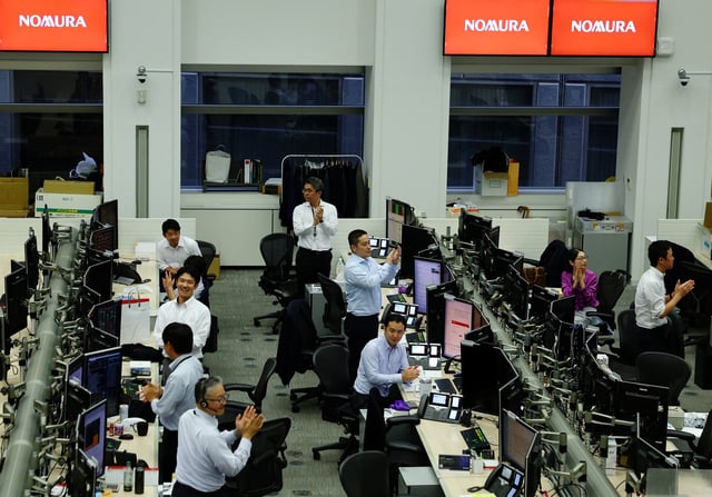 Traders clap as the Nikkei index closes at an all-time high, at the dealing room of Nomura Securities in Tokyo, Japan, August 12, 2025. REUTERS/Kim Kyung-Hoon