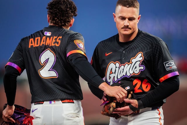 Giants shortstop Willy Adames, handing third baseman Matt Chapman his gear between innings, started slowly in 2025 but rebounded to hit 30 home runs for the season.