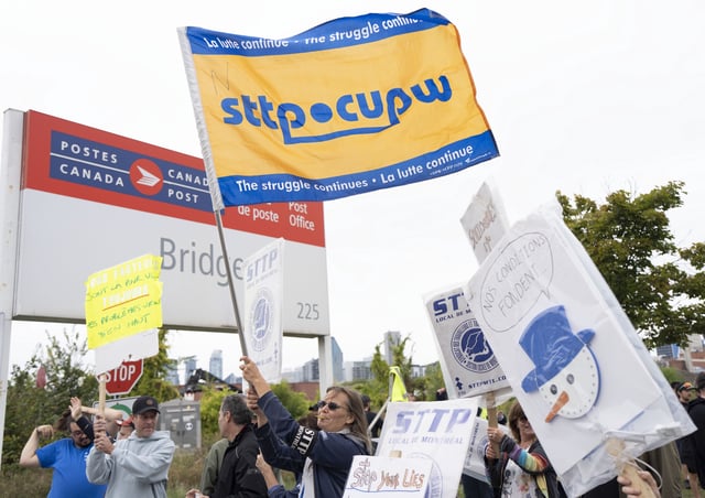 Canada Post workers picket outside a distribution centre as part of a strike action in Montreal on Friday, Sept. 26, 2025. THE CANADIAN PRESS/Christinne Muschi