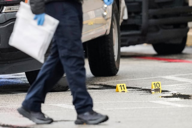 Bullets are marked on the ground as law enforcement officers salute as slain Brazoria County Sheriff's Office deputy Jesus Vargas, who was fatally shot while trying to serve an arrest warrant, is escorted by honor guard into the Harris County Forensic Science Center on Wednesday, Jan. 15, 2025, in Houston. (Brett Coomer/Houston Chronicle via AP)
