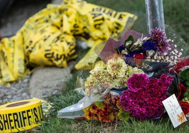 Flowers rest at a road block on McCandlish Road in Grand Blanc Township on Sept. 29, 2025, near the scene where a mass shooting occurred at The Church of Jesus Christ of Latter-day Saints in Grand Blanc Township on Sunday.