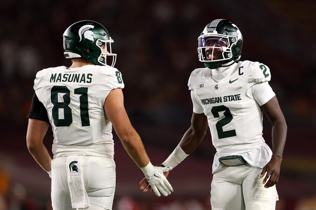 Michael Masunas #81 and Aidan Chiles #2 of the Michigan State Spartans embrace against the USC Trojans at Los Angeles Memorial Coliseum on September 20, 2025 in Los Angeles, California.