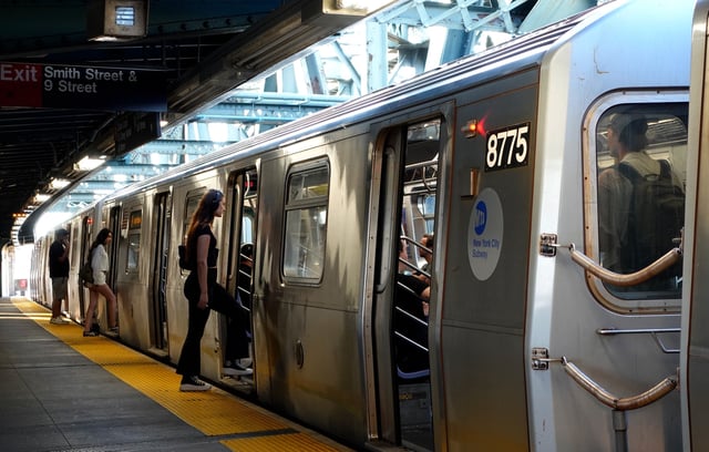 NEW YORK, NY - AUGUST 1: People board an F-line train at the Smith Street - 9th Street subway station on August 1, 2025, in New York City.  (Photo by Gary Hershorn/Getty Images)
