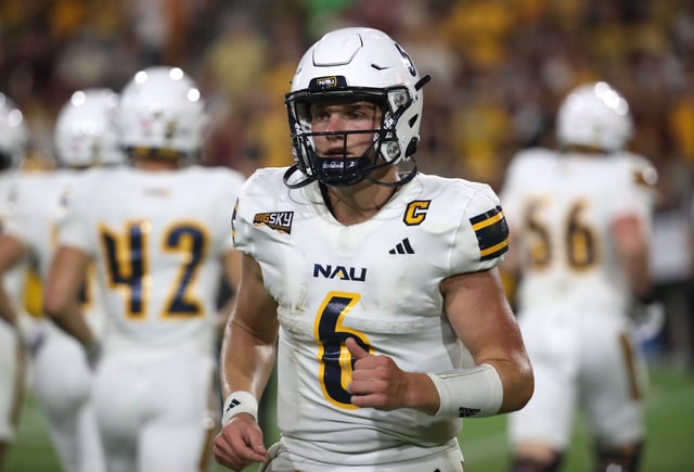 Quarterback Ty Pennington #6 of the NAU Lumberjacks jogs back to the sidelines after a loss of downs during the second half of the Northern Arizona University Lumberjacks versus the Arizona State University Sun Devils football game at Mountain America Stadium on August 30, 2025 in Tempe, Arizona.
