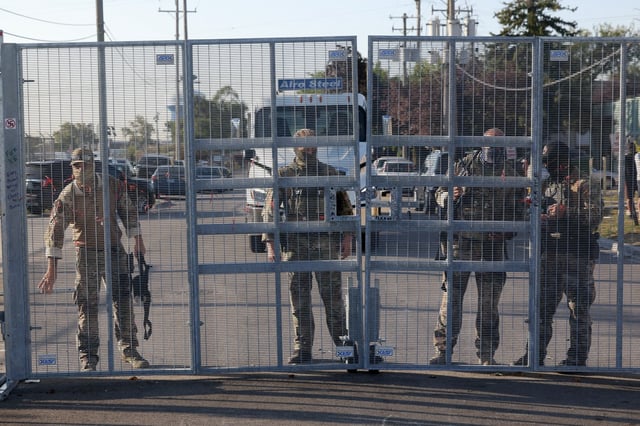 Federal agents prepare to open up the gate to the fence outside the U.S. Immigration and Customs Enforcement holding facility in Broadview, Sept. 30, 2025.  (Antonio Perez/Chicago Tribune)