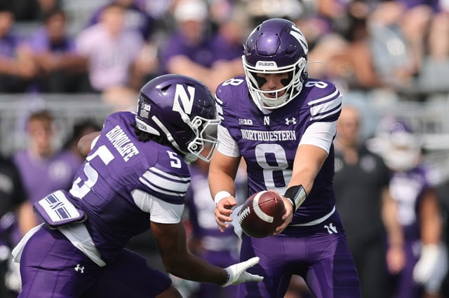 Northwestern quarterback Preston Stone hands off to running back Caleb Komolafe during the first half against Oregon on Sept. 13, 2025, in Evanston.  (Michael Reaves/Getty Images)