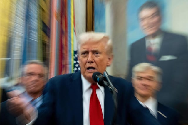 En la imagen, lograda con una baja velocidad de obturador, el presidente estadounidense Donald Trump habla en la Oficina Oval de la Casa Blanca, el martes 30 de septiembre de 2025, en Washington. (AP Foto/Alex Brandon)