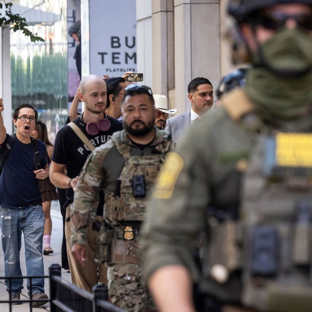 Pedestrians chant, "ICE go home!" as federal immigration agents walk along North Clark Street in the River North neighborhood, Sunday, Sept. 28, 2025, in Chicago. (Ashlee Rezin/Chicago Sun-Times via AP)
