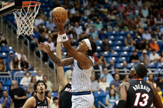 Orlando Magic forward Paolo Banchero, center, drives to the basket against the Miami Heat during the first half of a  preseason NBA basketball game in San Juan, Puerto Rico, Saturday, Oct. 4, 2025. (AP Photo/Alejandro Granadillo)