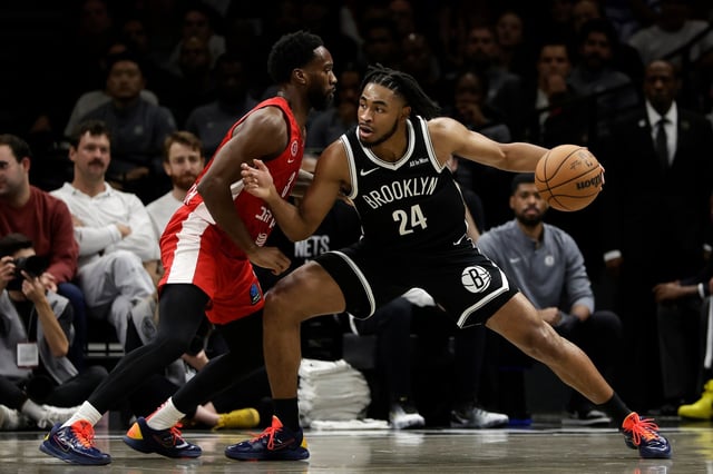 Brooklyn Nets guard Cam Thomas (24) looks to drive around Hapoel Jerusalem guard Khadeen Carrington, left, during the first half of a preseason NBA basketball game Saturday, Oct. 4, 2025, in New York. (AP Photo/Adam Hunger)