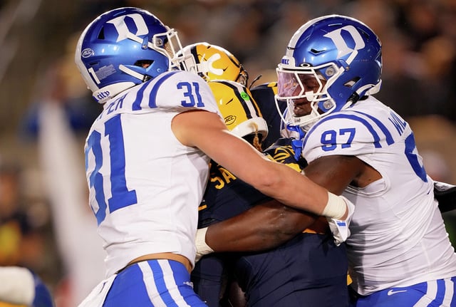Duke’s Elliott Schaper, left, and Wesley Williams combine for a second-quarter sack of Cal quarterback Jaron-Keawe Sagapolutele on Saturday at Memorial Stadium.