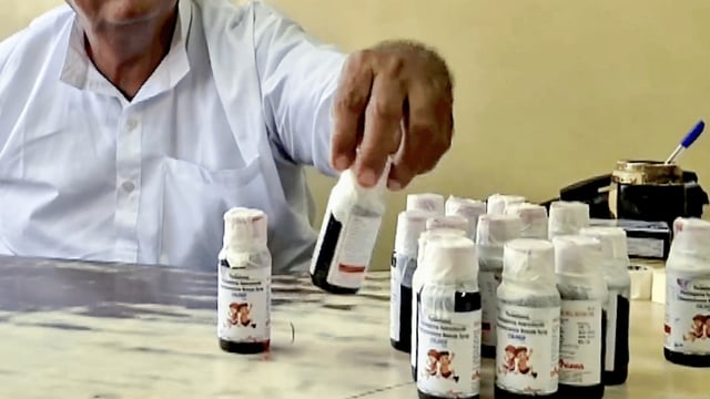 official looks at bottles of the Coldrif ough syrup after a raid by the Drug and Pharmaceuticals Department officials at Kataria Pharmaceuticals, after the deaths of 11 children, nine in Madhya Pradesh and two in Rajasthan, allegedly linked to contaminated cough syrup, in Jabalpur, Madhya Pradesh, Saturday, Oct. 4, 2025 | PTI