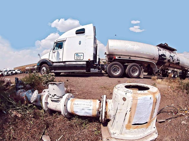 Toma clandestina de agua y un tráiler al fondo.