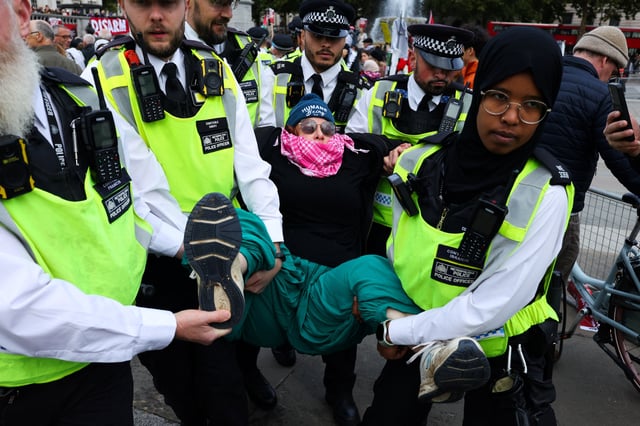 Police officers detain a protester during a mass demonstration organised by Defend our Juries, against the British government's ban on Palestine Action, at Trafalgar Square in London, Britain, October 4, 2025. REUTERS/Toby Melville
