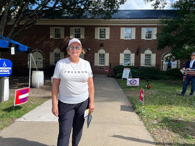 Grace Cook, a Republican volunteer, poses for a picture outside the early voting location in Virginia Beach, Virginia, U.S., October 2, 2025. REUTERS/Nathan Layne