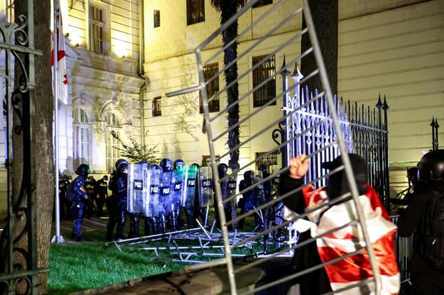 Des manifestants face à la police anti-émeute alors qu'ils tentent de pénétrer dans l'enceinte du palais présidentiel lors d'un rassemblement de l'opposition le jour des élections locales, le 4 octobre 2025 à Tbilissi, en Géorgie
