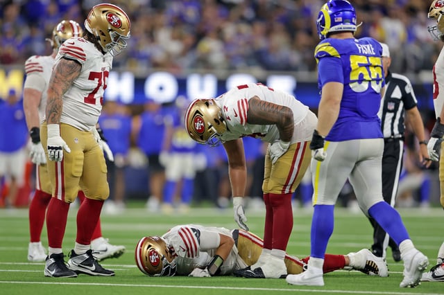 Niners guard Dominick Puni checks on quarterback Mac Jones in the fourth quarter of Thursday’s 26-23 win in overtime over Rams at SoFi Stadium.