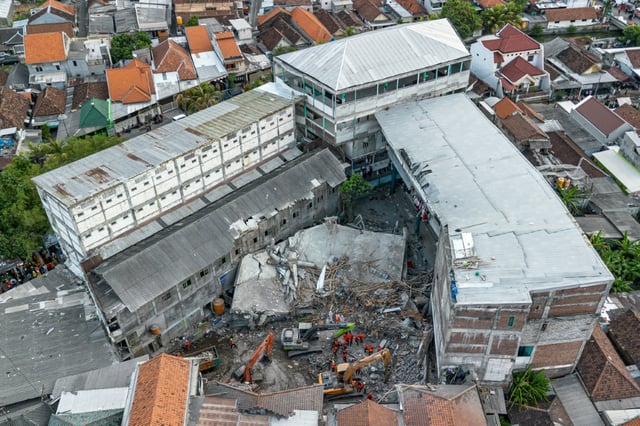 Vue aérienne des sauveteurs à la recherche de victimes à l'école islamique Al Khoziny à Sidoarjo, dans la province de Java oriental, après l'effondrement d'un bâtiment pendant les prières, le 5 octobre 2025 en Indonésie