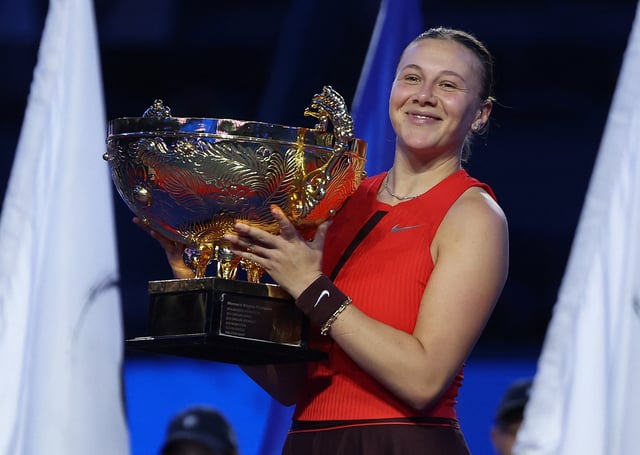 Tennis - China Open - The Beijing Olympic Green Tennis Center, Beijing, China - October 5, 2025 Amanda Anisimova of the U.S. celebrates with the trophy after winning her singles final match against Czech Republic's Linda Noskova REUTERS/Maxim Shemetov