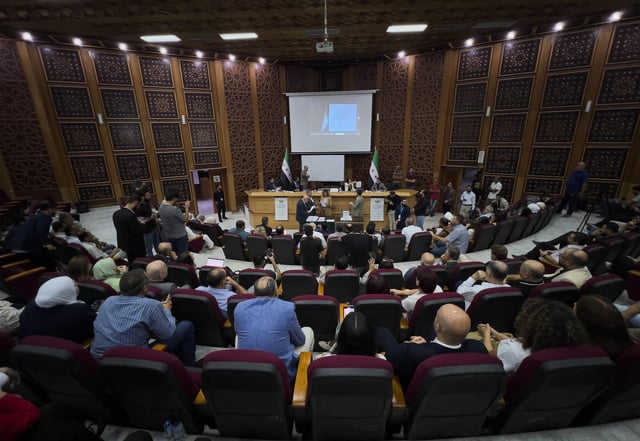 Syrian electoral college members and candidates attend the ballots' count shortly after polling stations closed at Latakia's Governor building, in the coastal city of Latakia, Syria, Sunday, Oct. 5, 2025. (AP Photo/Hussein Malla)