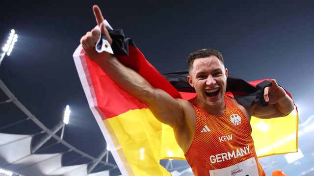 Felix Streng hält Deutschland-Flagge jubelnd in die Kamera