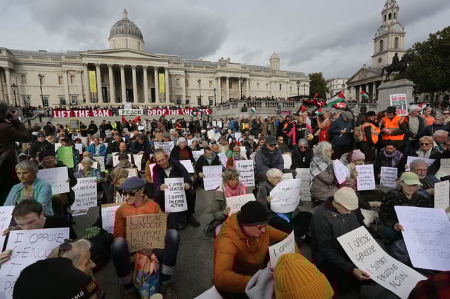 Pro-Palestinian activists hold signs during a demonstration in Trafalgar Square, central London, Saturday.