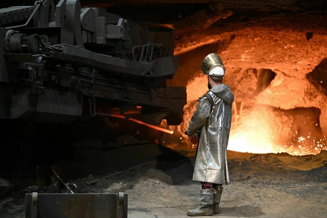 Ein Stahlarbeiter steht an einem Hochofen von Thyssenkrupp Steel.