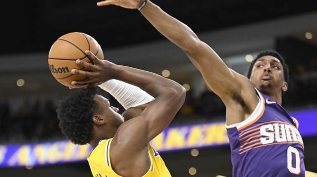 Oct 3, 2025; Palm Desert, California, USA; Los Angeles Lakers guard Bronny James (9) tries to shoot past Phoenix Suns forward Ryan Dunn (0) during the first half at Acrisure Arena. Mandatory Credit: Denis Poroy-Imagn Images