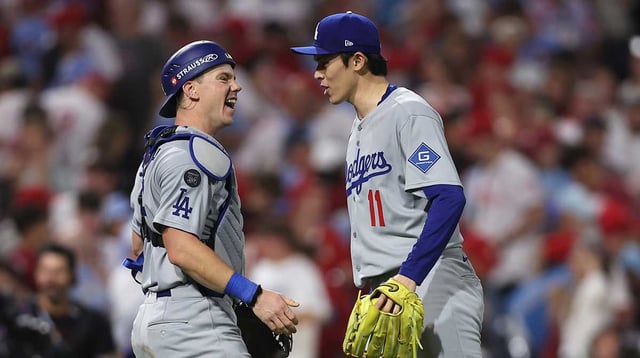 Oct 4, 2025; Philadelphia, Pennsylvania, USA; Los Angeles Dodgers pitcher Roki Sasaki (11) and catcher Will Smith (16) celebrate after defeating the Philadelphia Phillies in game one of the NLDS round for the 2025 MLB playoffs at Citizens Bank Park. Mandatory Credit: Bill Streicher-Imagn Images