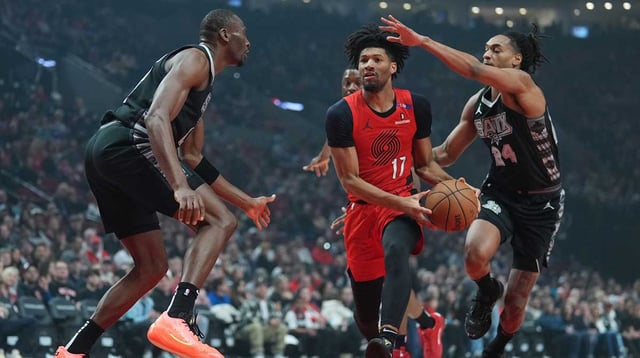 Apr 6, 2025; Portland, Oregon, USA; Portland Trail Blazers shooting guard Shaedon Sharpe (17) drives for the basket between San Antonio Spurs center Bismack Biyombo (18) and shooting guard Devin Vassell (24) during the first half at Moda Center. Mandatory Credit: Soobum Im-Imagn Images
