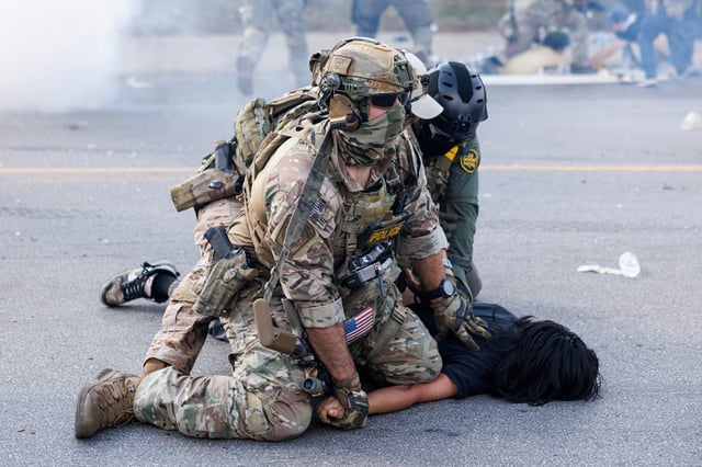 Federal officers hold down a protestor in the Brighton Park neighborhood of Chicago, on Saturday, Oct. 4, 2025, after protesters learned that U.S. Border Patrol shot a woman Saturday morning on Chicago's Southwest Side. (Anthony Vazquez/Chicago Sun-Times via AP)